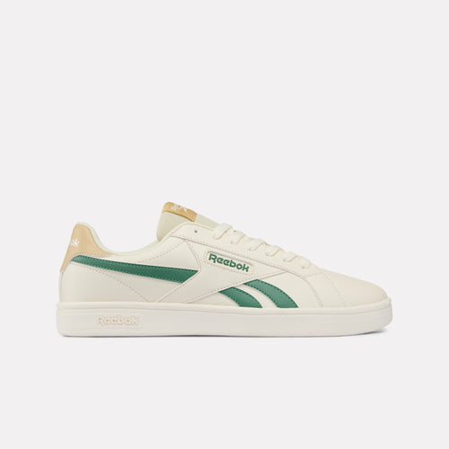 White Reebok sneaker with green accents on a light gray background