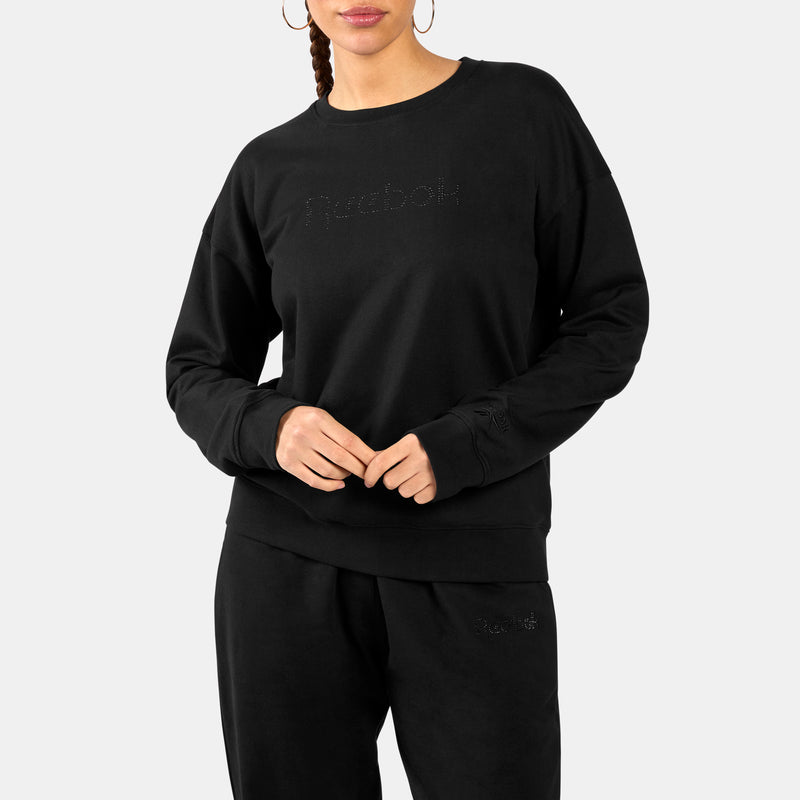 Person wearing a black Studded Logo Women's Crew Sweatshirt with a brand logo on a white background