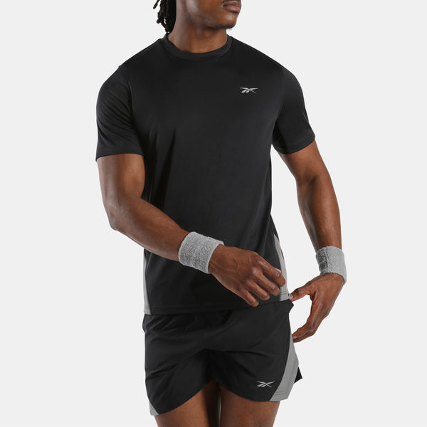 Person wearing a black athletic outfit with Reebok logo on a white background