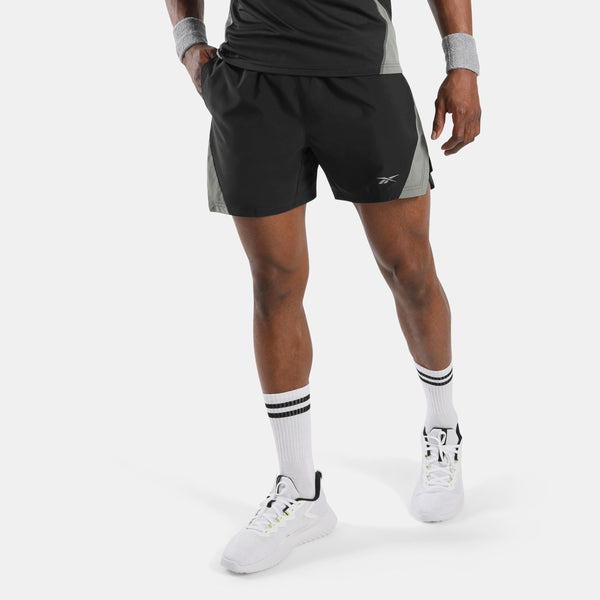 Person wearing black athletic shorts with a brand logo on a white background