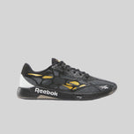 Black Reebok sneaker with yellow accents on a white background